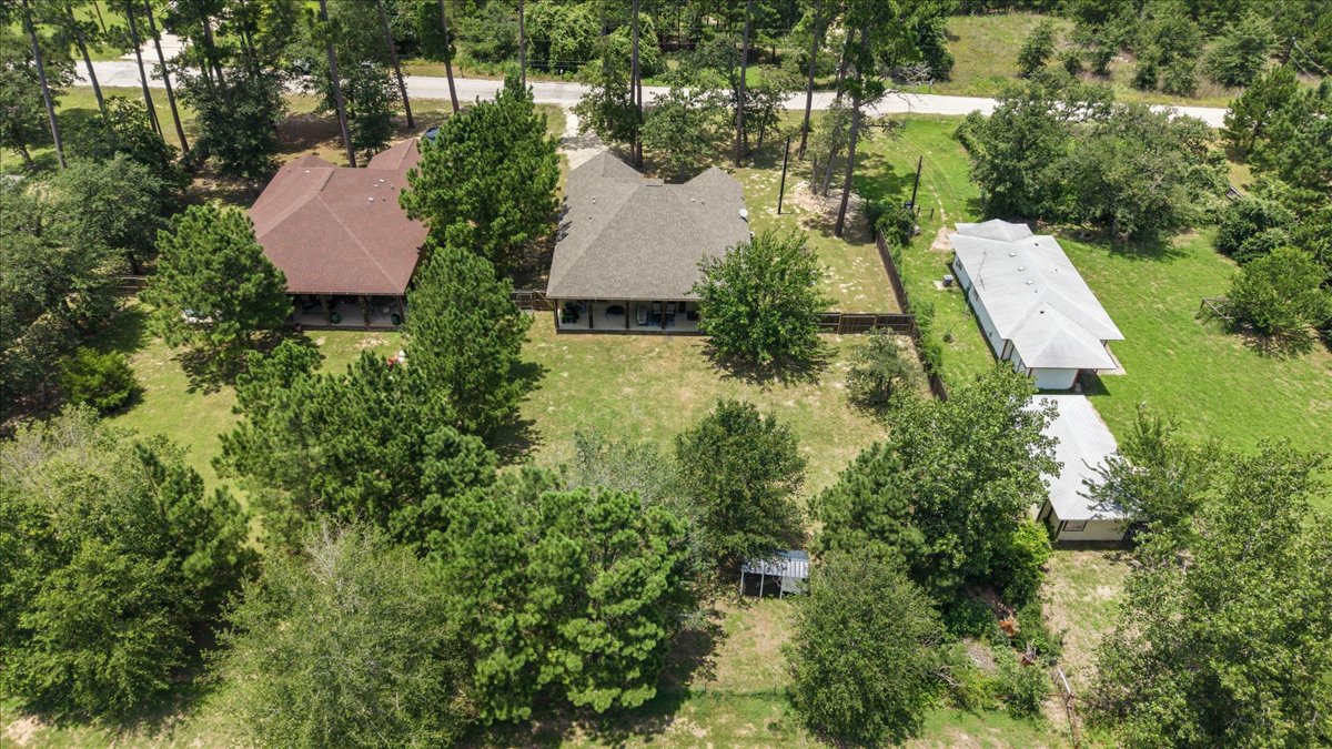 145 Cardinal Loop Paige, TX 78659 - Photo 37 of 40 An aerial perspective reveals two residential structures nestled among mature trees on a verdant lot.