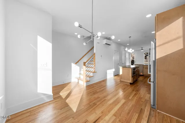 a kitchen with kitchen island wooden floors appliances and cabinets