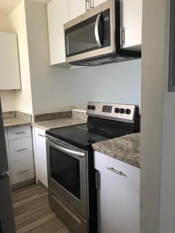 a stove top oven sitting inside of a kitchen
