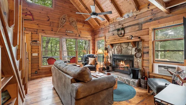 a living room with furniture a fireplace and a floor to ceiling window