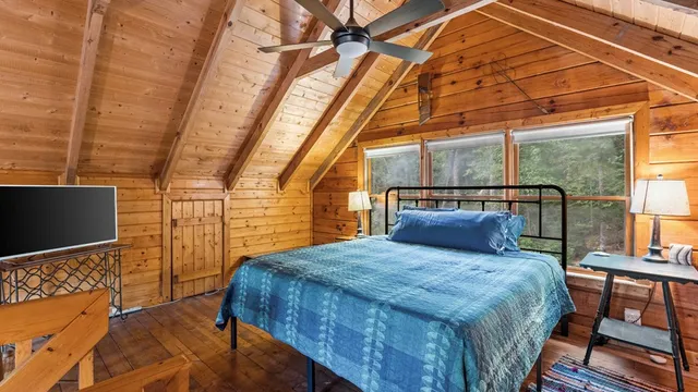 a bedroom with a bed and wooden floor