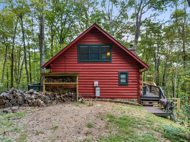a backyard of a house with wooden fence and large trees