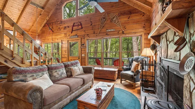 a living room with furniture a rug and a floor to ceiling window