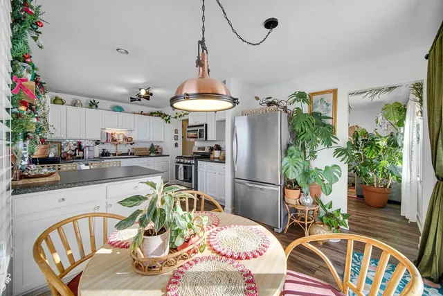 a dining room with furniture a chandelier and wooden floor