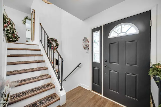 a view of a livingroom with wooden floor and staircase