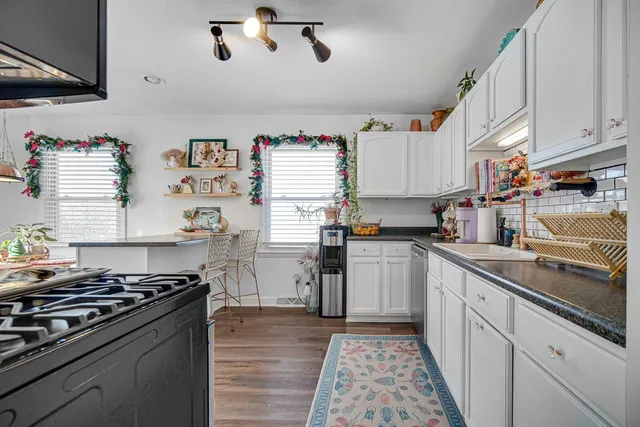 a kitchen with granite countertop stainless steel appliances sink and cabinets