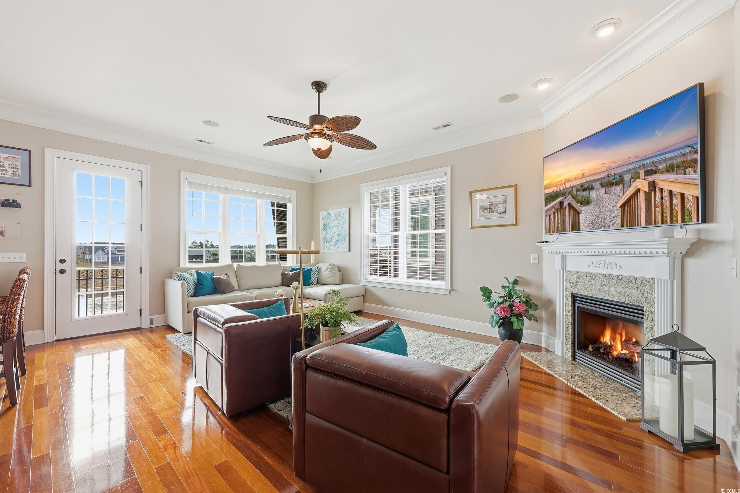 349 St.Julian Lane Myrtle Beach, SC 29579 - Photo 11 of 40 Living area with a fireplace with flush hearth, ornamental molding, ceiling fan, and wood-type flooring