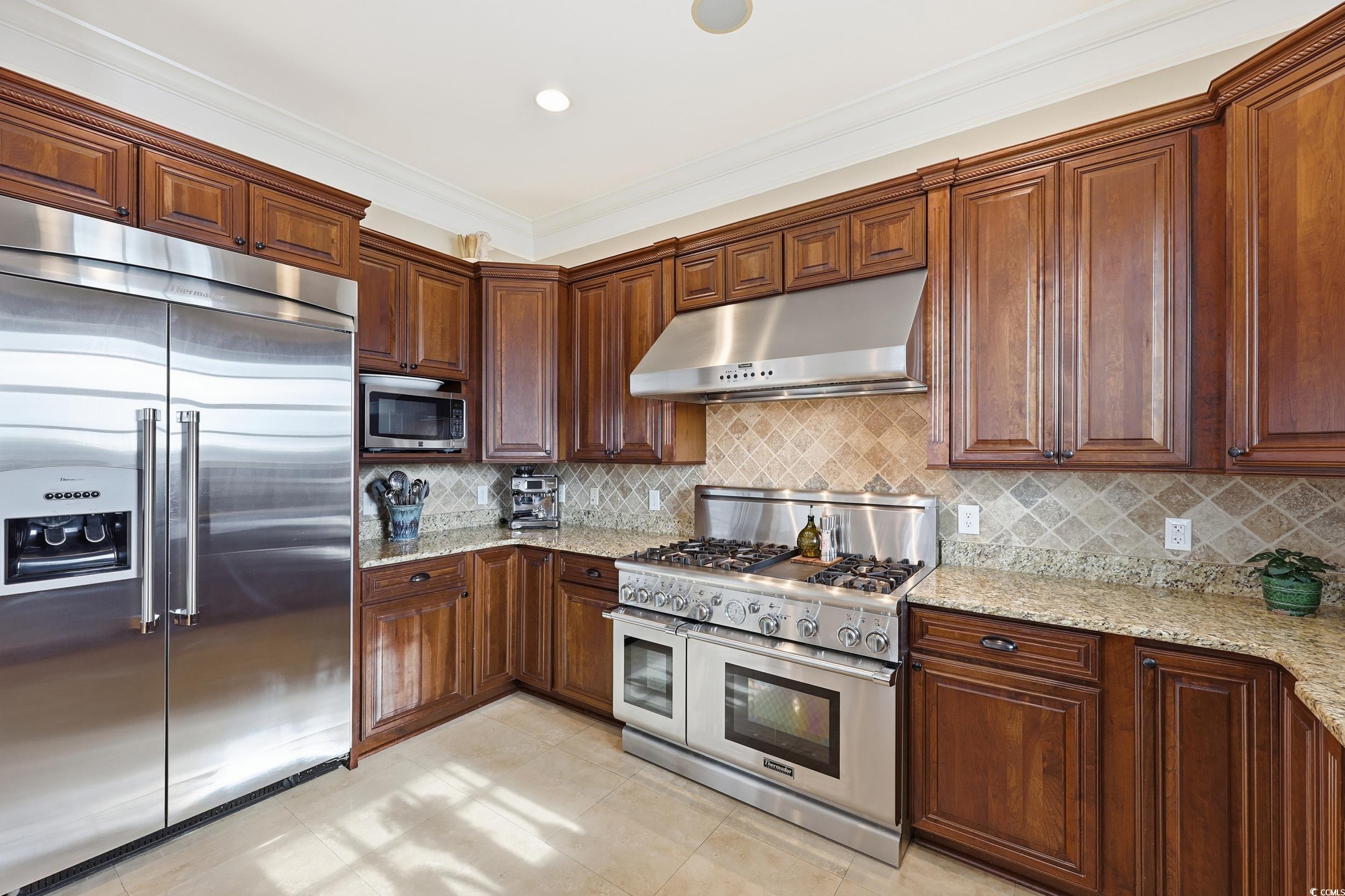 349 St.Julian Lane Myrtle Beach, SC 29579 - Photo 10 of 40 Kitchen featuring high quality appliances, under cabinet range hood, light stone counters, backsplash, and ornamental molding