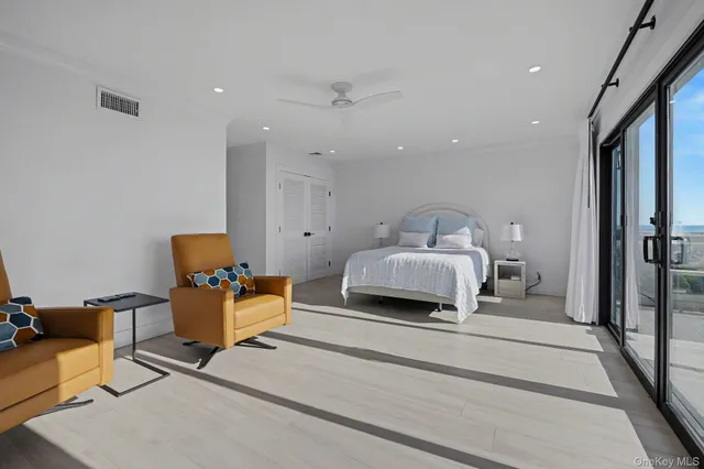 a spacious bedroom with a bed and a chandelier