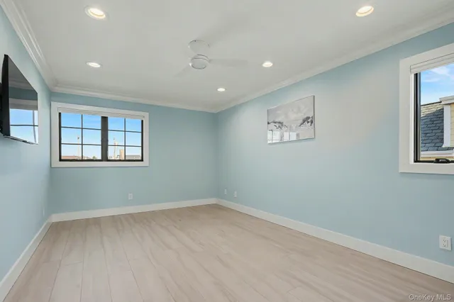 a view of a big room with wooden floor and windows