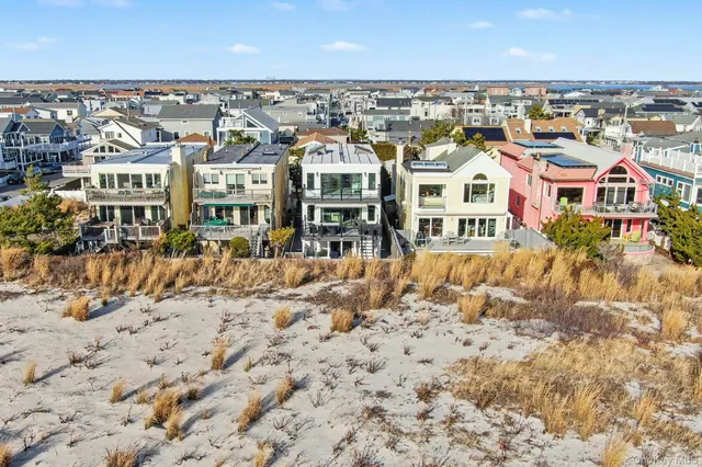 an aerial view of residential houses with outdoor space and trees