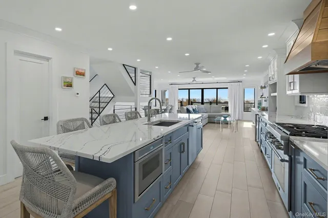 a large kitchen with stainless steel appliances granite countertop a lot of counter space and a sink