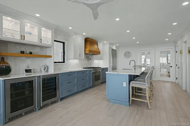 a kitchen with stainless steel appliances granite countertop wooden cabinets a sink a stove a dining table and chairs