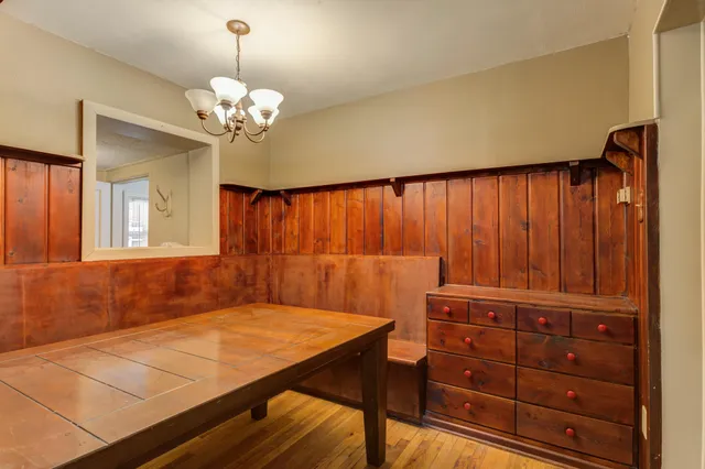 a view of a room with a dresser chandelier and wooden floor
