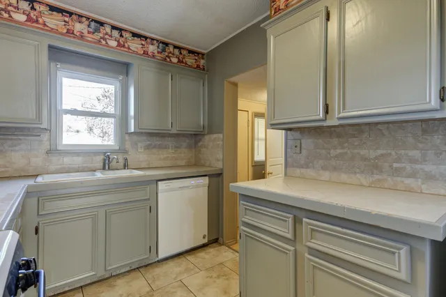 a kitchen with white cabinets and a sink