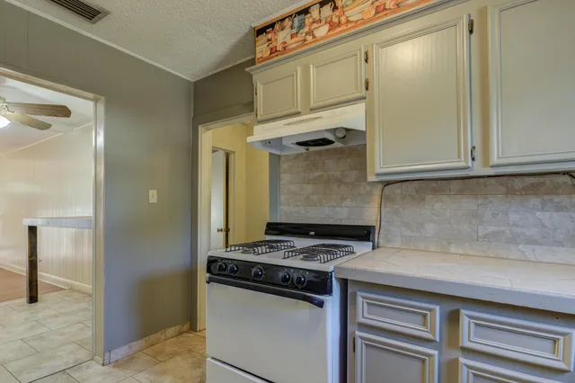 a kitchen with stainless steel appliances granite countertop a refrigerator and a stove