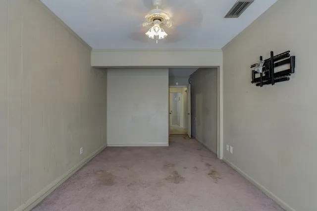 en empty room with a ceiling fan and window