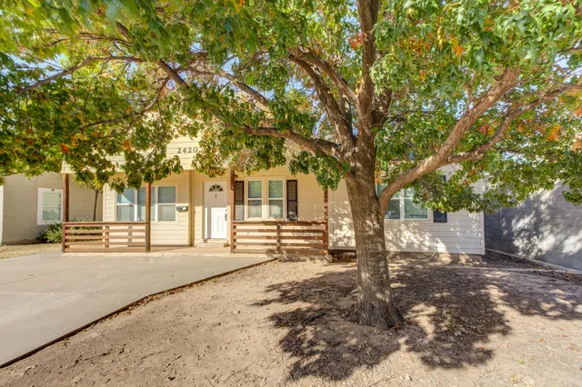 a front view of a house with a tree