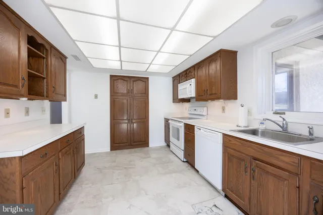 a large kitchen with kitchen island granite countertop a sink stainless steel appliances and cabinets