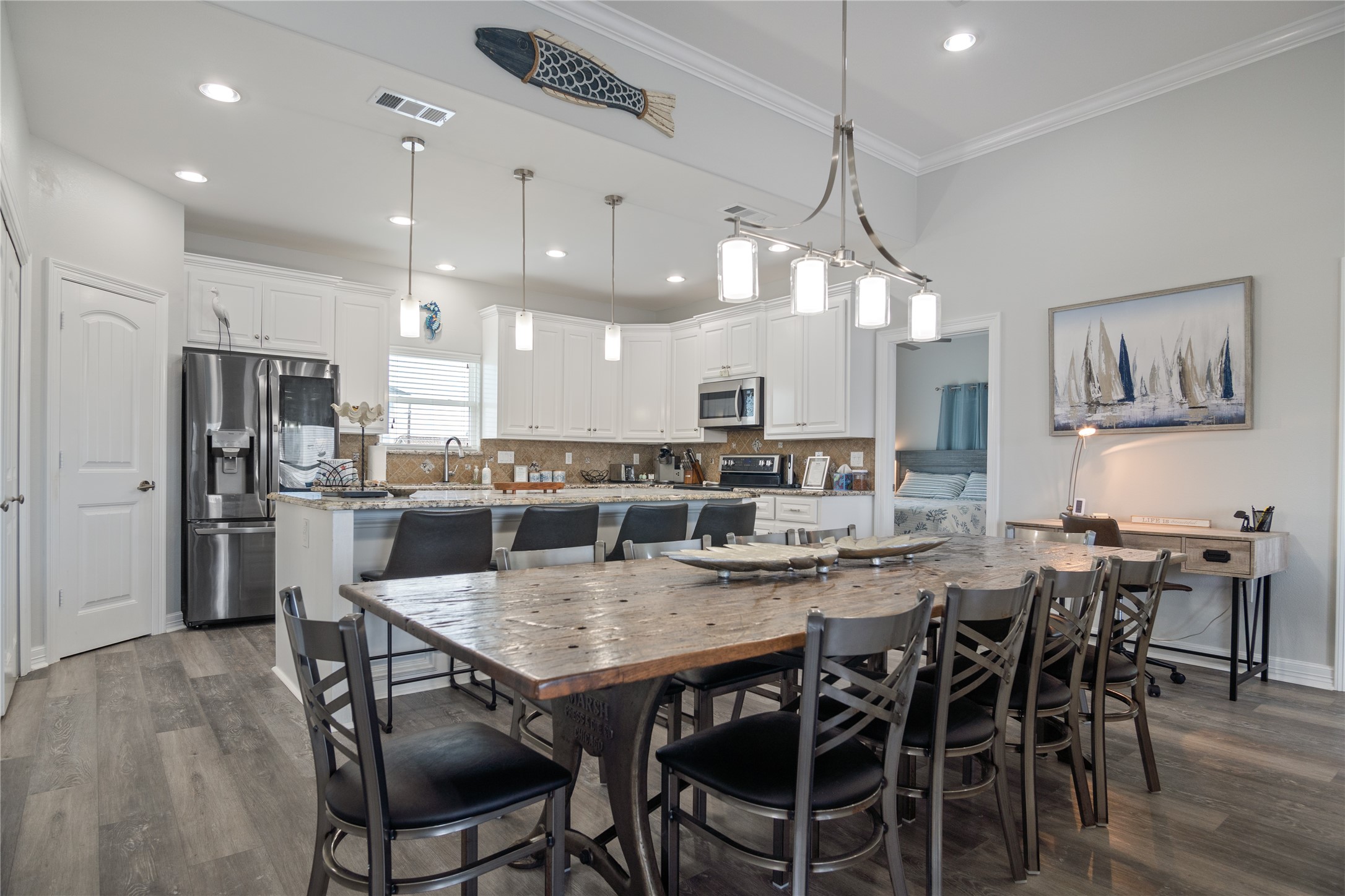 a kitchen with a dining table chairs stainless steel appliances and cabinets