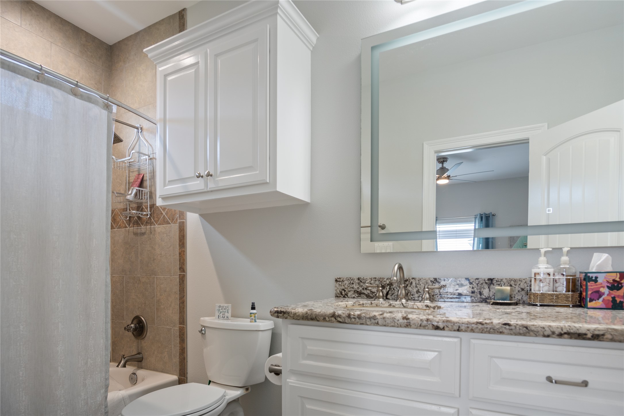 956 Biscayne Crystal Beach, TX 77650 - Photo 14 of 46 a bathroom with a granite countertop sink toilet and mirror