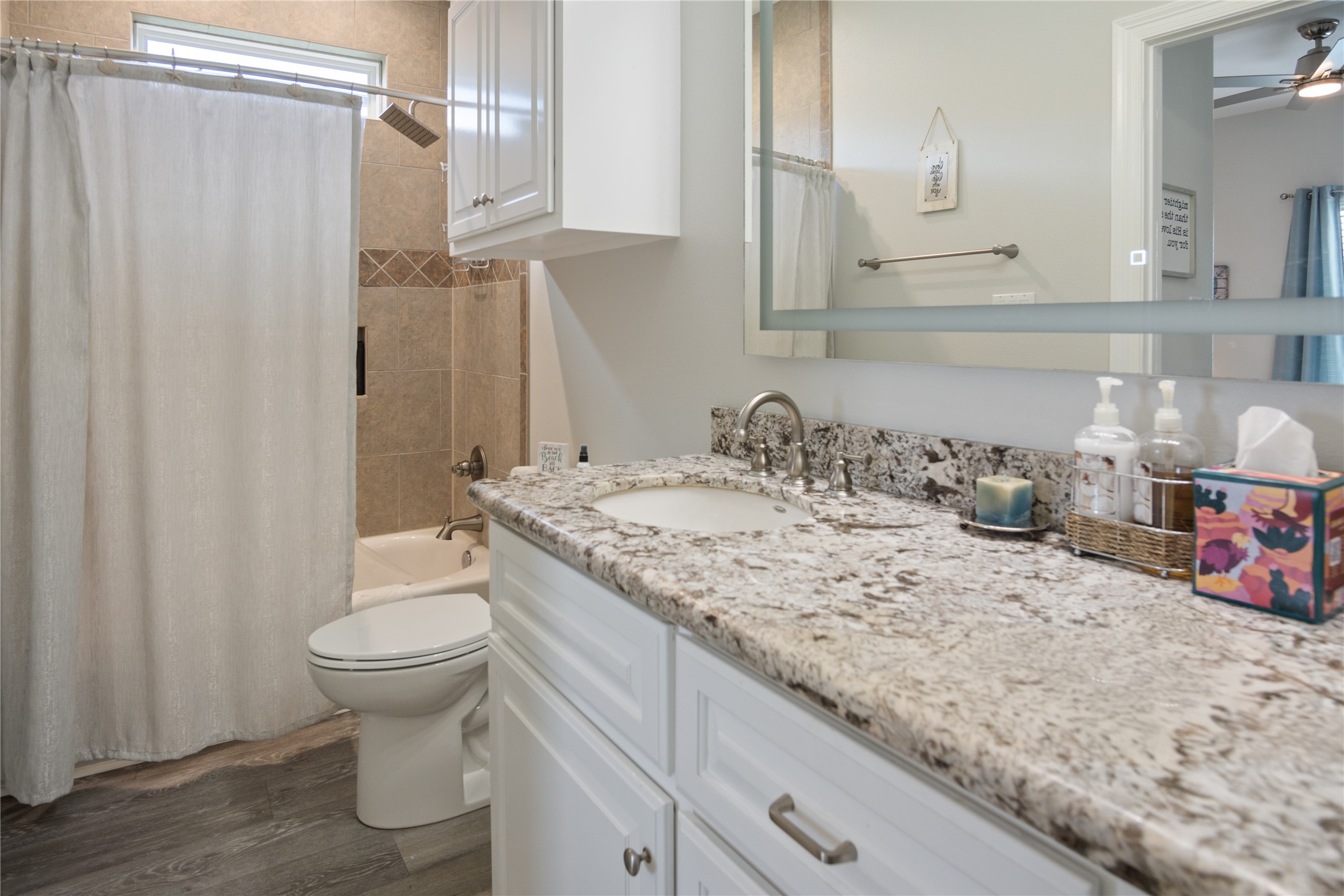956 Biscayne Crystal Beach, TX 77650 - Photo 15 of 46 a bathroom with a granite countertop sink a toilet and a shower curtain