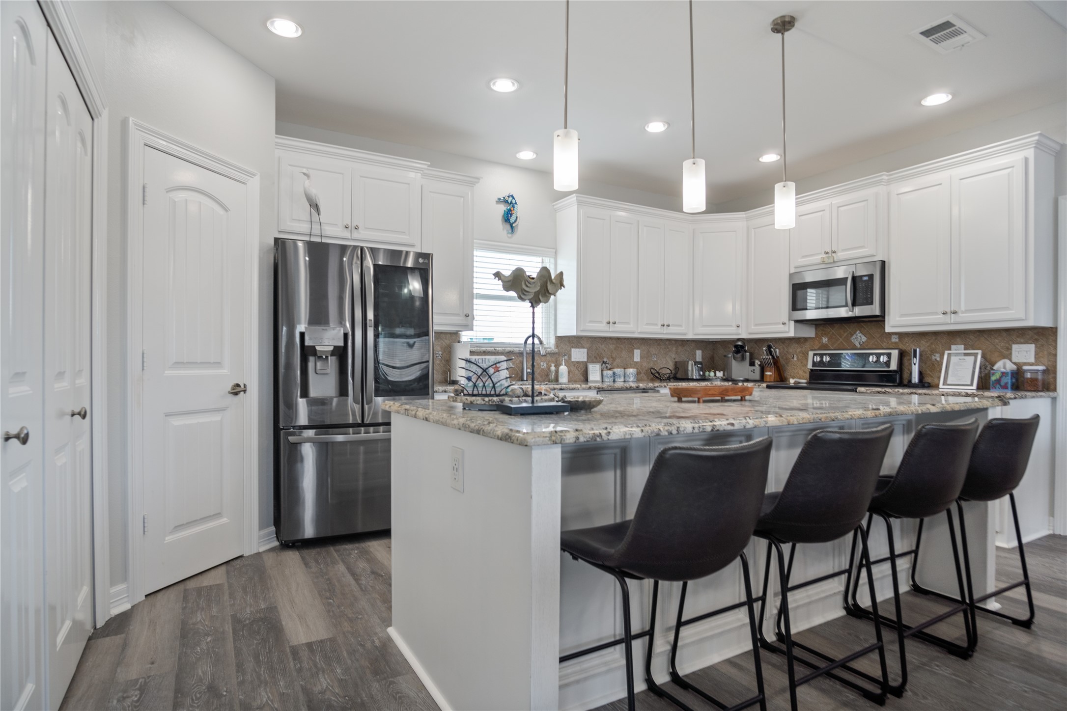 956 Biscayne Crystal Beach, TX 77650 - Photo 3 of 46 a kitchen with stainless steel appliances granite countertop a stove a refrigerator a kitchen island a sink and a refrigerator