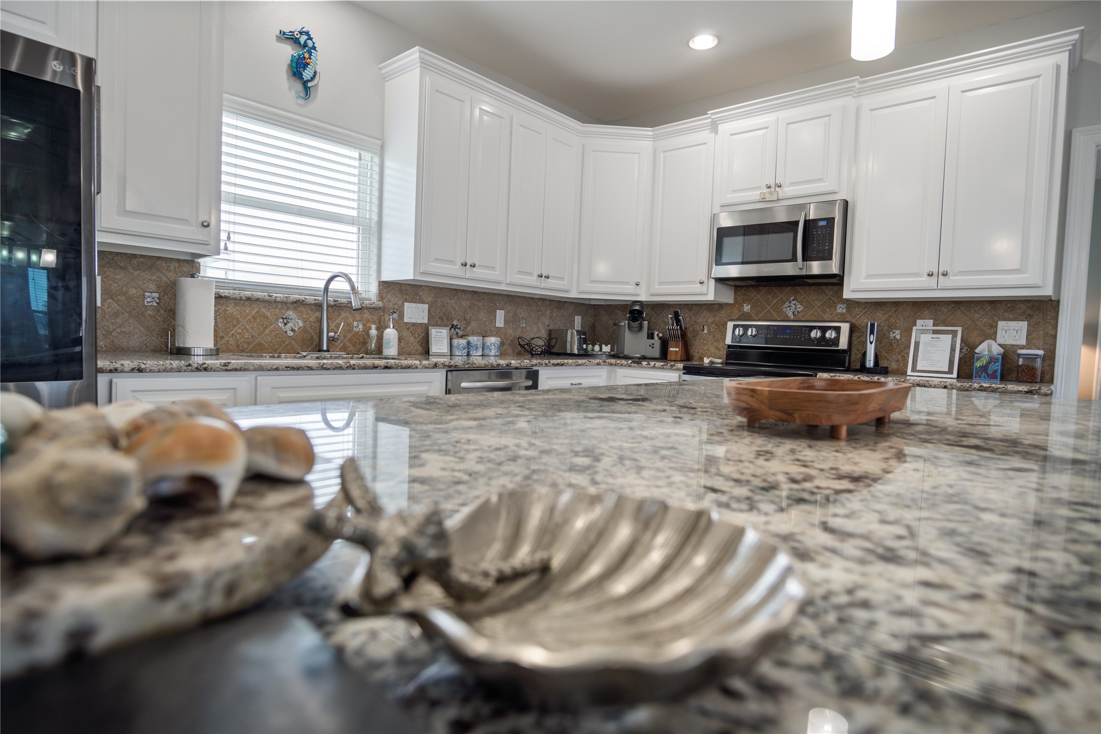 956 Biscayne Crystal Beach, TX 77650 - Photo 5 of 46 a kitchen with stainless steel appliances granite countertop a sink a stove a microwave a sink and cabinets