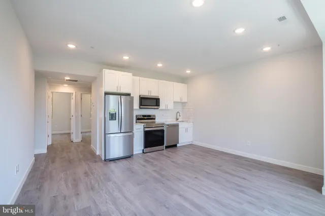 a view of kitchen with stainless steel appliances a refrigerator and a stove top oven