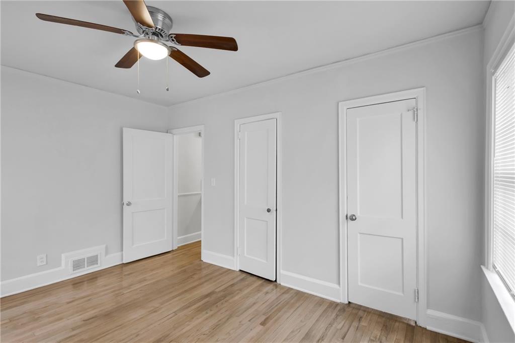 2880 Old Lost Mountain Road, Unit A Powder Springs, GA 30127 - Photo 12 of 23 an empty room with wooden floor ceiling fan and windows