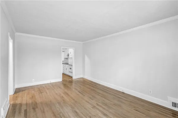 a view of an empty room with wooden floor