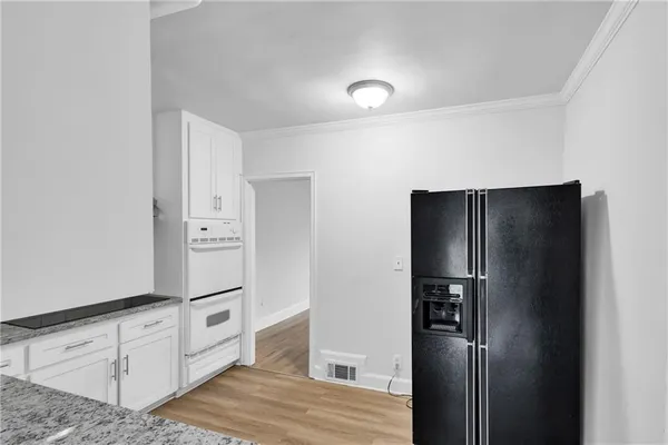 a kitchen with white cabinets and refrigerator