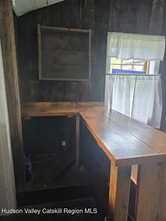 a view of a room with wooden walls and windows