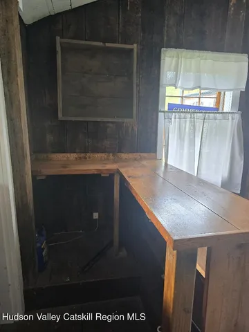 a view of a room with wooden walls and windows