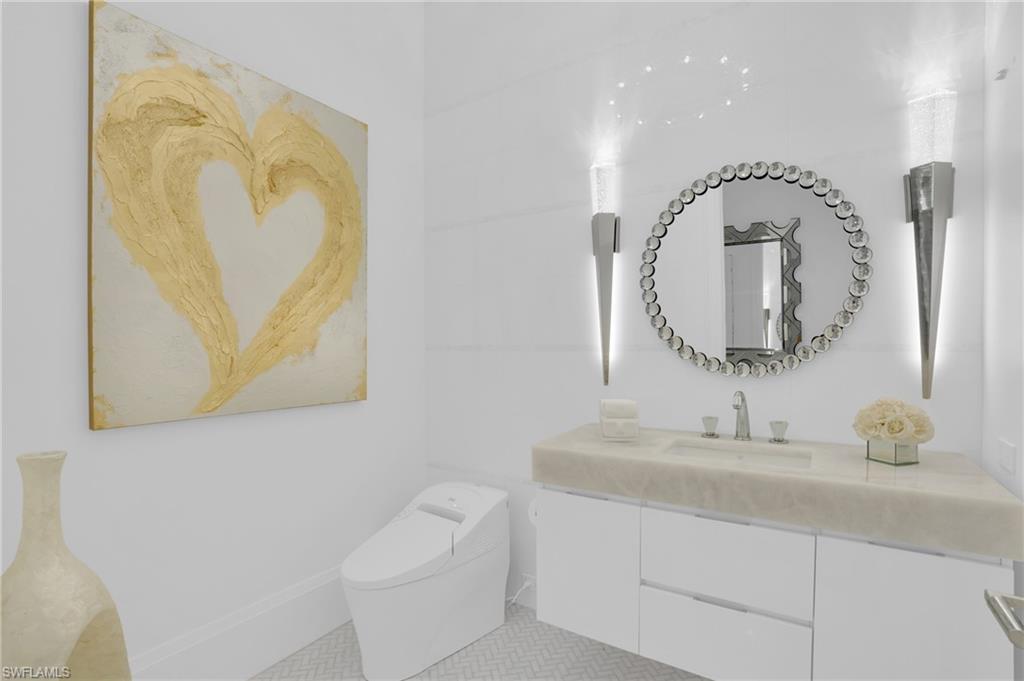 3110 Leeward Lane Naples, FL 34103 - Photo 18 of 50 a bathroom with a toilet sink and mirror