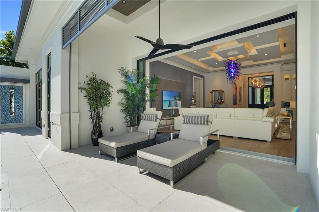 3110 Leeward Lane Naples, FL 34103 - Photo 32 of 50 a living room with furniture and a chandelier