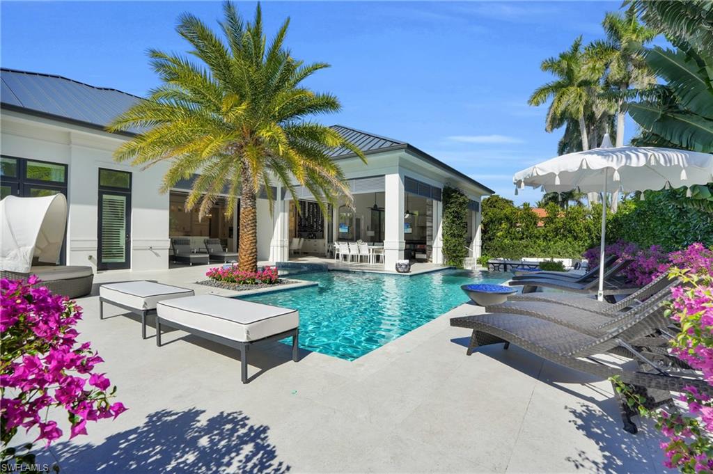 3110 Leeward Lane Naples, FL 34103 - Photo 40 of 50 a view of a house with backyard sitting area and swimming pool