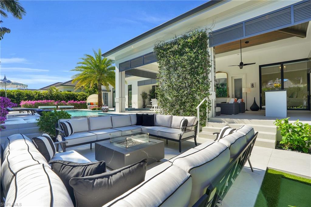 3110 Leeward Lane Naples, FL 34103 - Photo 47 of 50 a view of a patio with couches table and chairs with potted plants and big yard