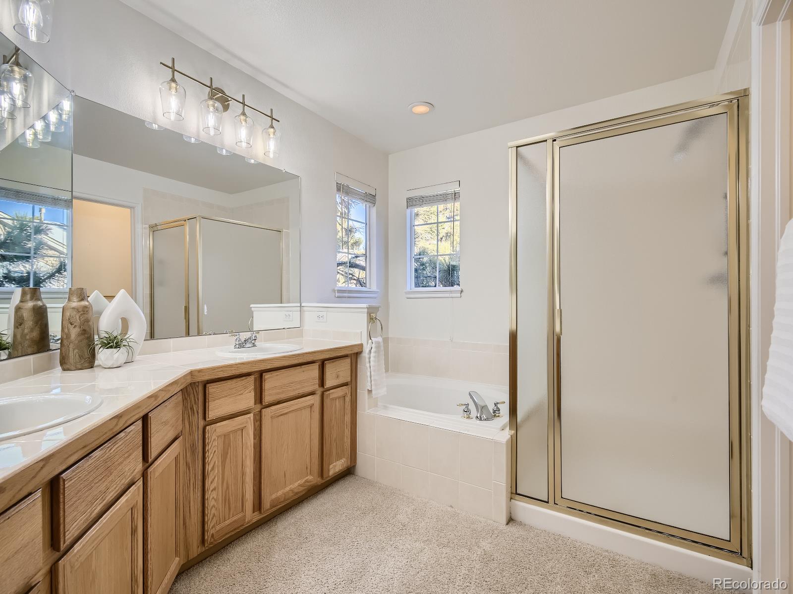 7400 West Grant Ranch Boulevard, Unit 60 Denver, CO 80123 - Photo 14 of 36 a spacious bathroom with a double vanity sink a mirror and a bathtub