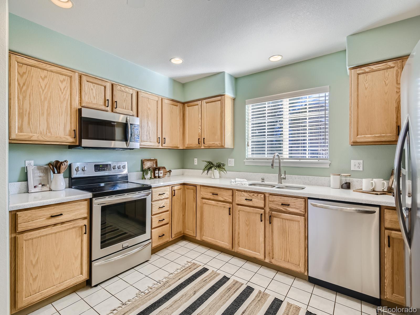 7400 West Grant Ranch Boulevard, Unit 60 Denver, CO 80123 - Photo 8 of 36 a kitchen with a sink stove and microwave
