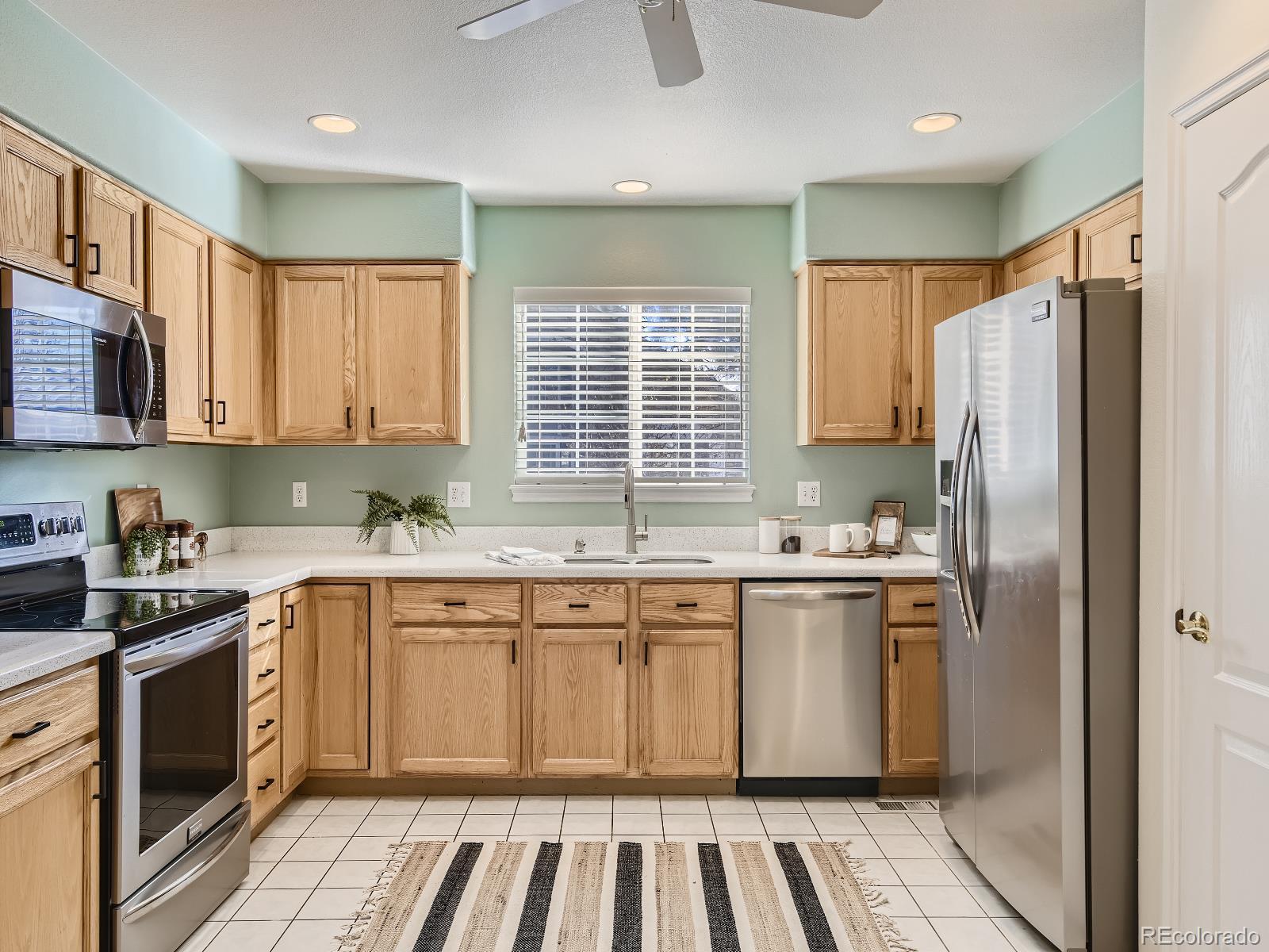 7400 West Grant Ranch Boulevard, Unit 60 Denver, CO 80123 - Photo 10 of 36 a kitchen with stainless steel appliances granite countertop a stove a sink and a refrigerator