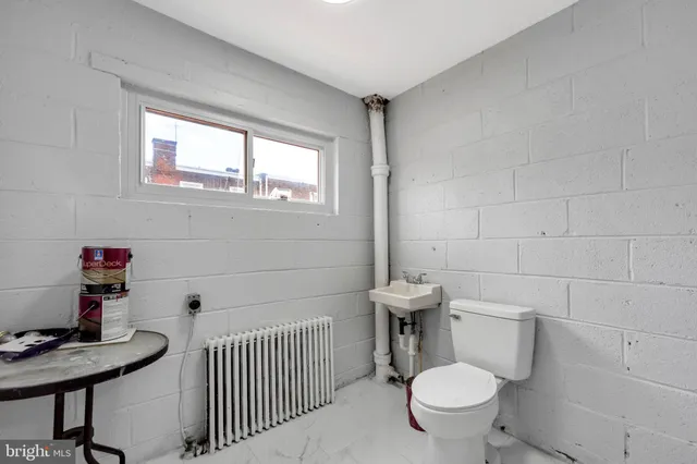 a bathroom with a toilet a sink and a window
