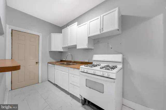 a kitchen with white cabinets and white appliances
