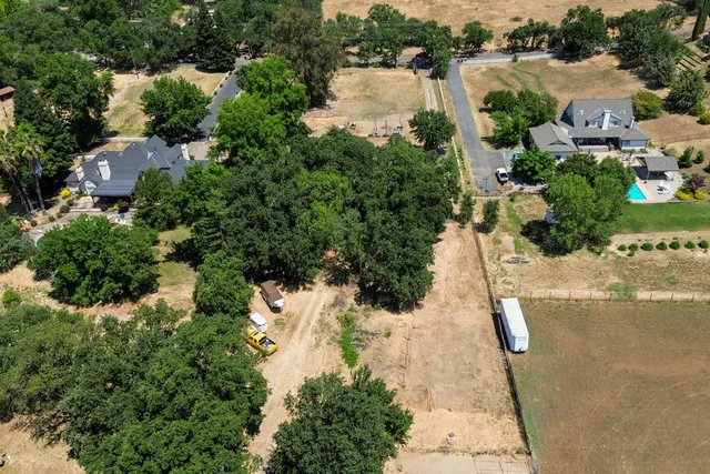 an aerial view of a house with a yard and lake view