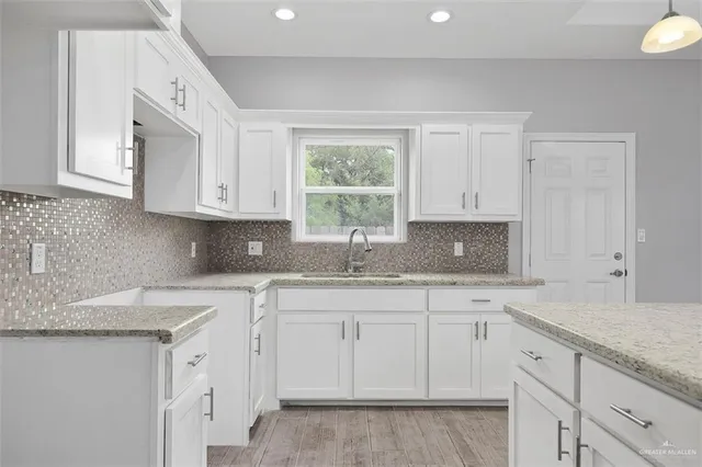 a kitchen with granite countertop white cabinets white appliances and a granite counter tops