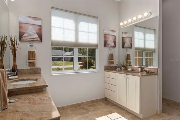 a kitchen with stainless steel appliances granite countertop a sink a stove a dining table and chairs
