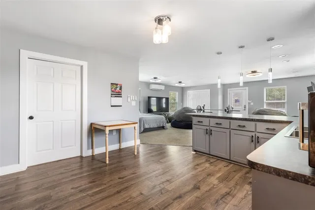 a kitchen with kitchen island granite countertop a sink cabinets and wooden floor