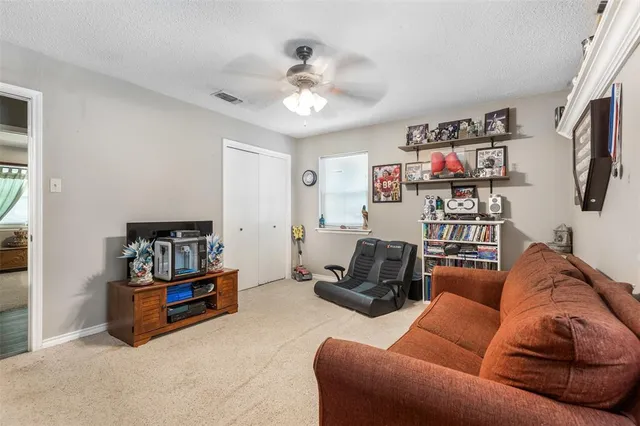 a living room with furniture a flat screen tv and a ceiling fan