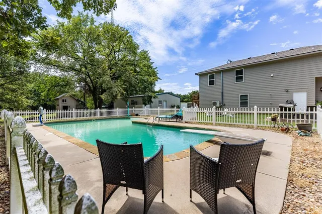 a swimming pool with outdoor seating and yard