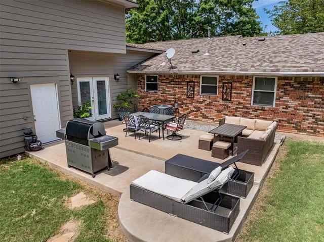 a view of a patio with couches table and chairs and potted plants